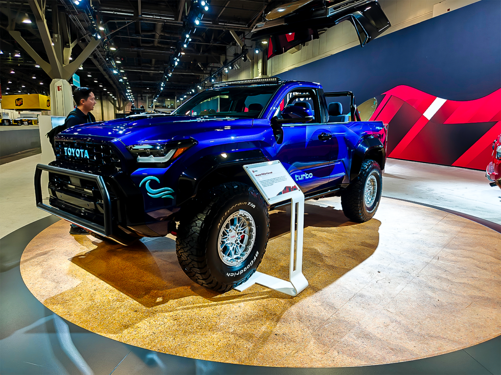 SEMA 2024 showcase featuring STILLEN's top picks: custom Nissan Z, Nissan Frontier Tarmac Edition, Infiniti QX80, Toyota Tacoma builds with Icon Vehicle Dynamics suspension, TruControl tuner, and TruPower intake, and Toyota's concept off-roaders including TRD Surf and Land Cruiser Rox