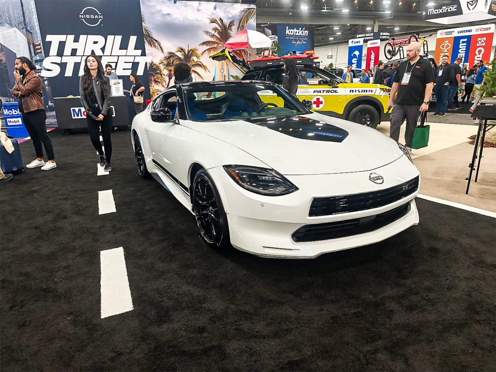 SEMA 2024 showcase featuring STILLEN's top picks: custom Nissan Z, Nissan Frontier Tarmac Edition, Infiniti QX80, Toyota Tacoma builds with Icon Vehicle Dynamics suspension, TruControl tuner, and TruPower intake, and Toyota's concept off-roaders including TRD Surf and Land Cruiser Rox